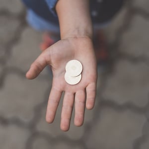 Child's hand holding two coins